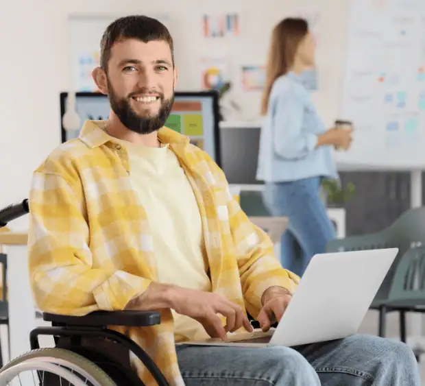 Pewna Praca z AI - osoba z niepełnosprawnością pracująca na laptopie